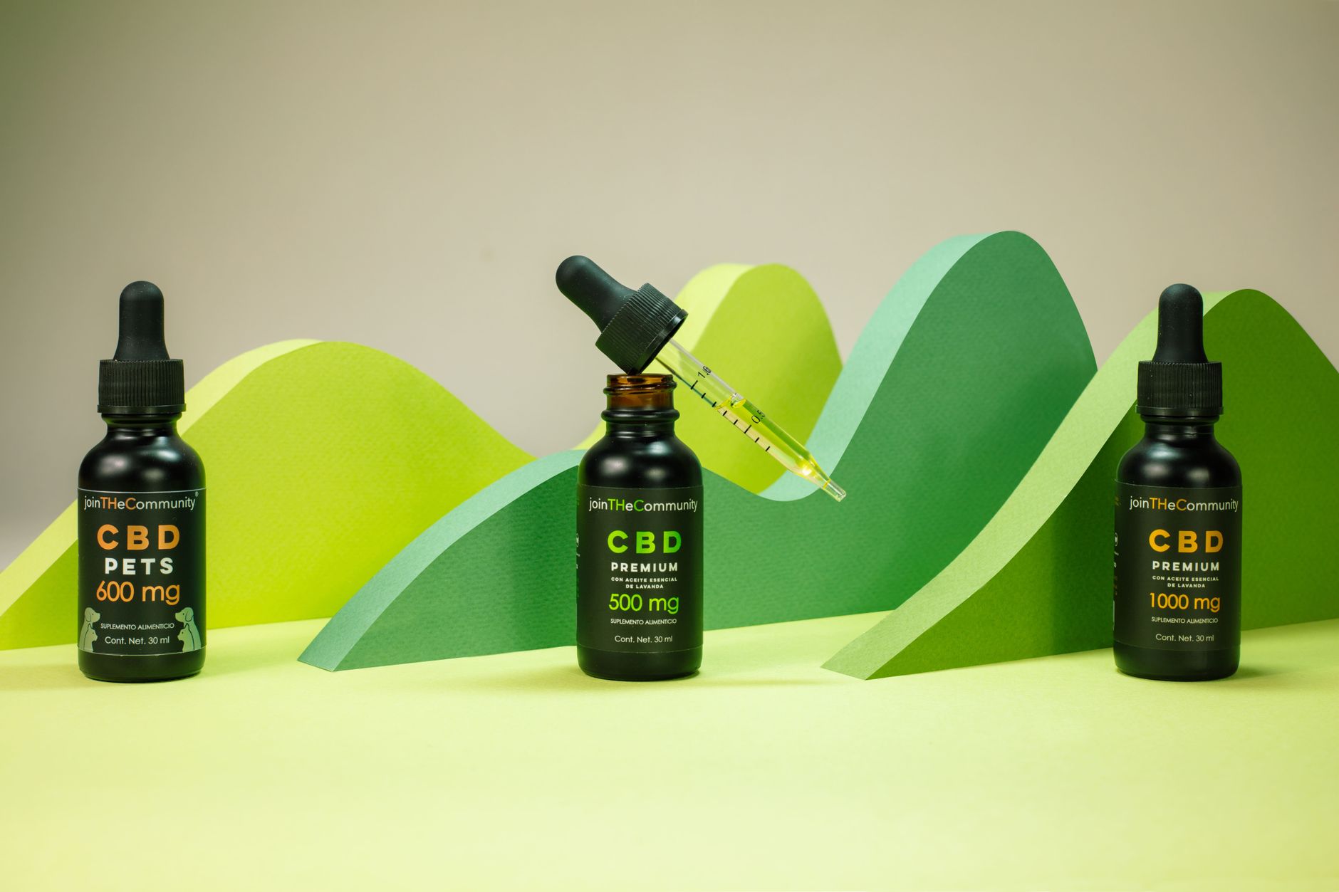 Mãos segurando um frasco conta-gotas de óleo de CBD ao ar livre.